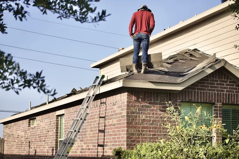 Professional roofer working on a residential roof in Montchanin